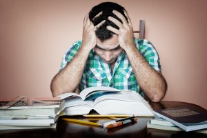 Grunge image of a stressed overworked man studying