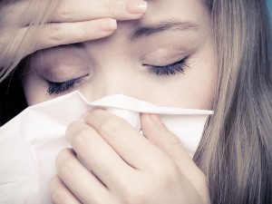 Flu Fever. Sick Girl Sneezing In Tissue. Health