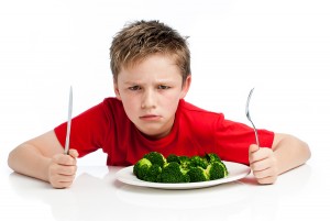 Handsome Young Boy Eating Broccoli